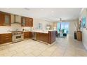 Open kitchen with custom cabinets, tile floors and stainless steel appliances overlooking ocean at 915 Seaside Dr # 405 Weeks 22-23, Sarasota, FL 34242