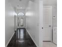 Hallway featuring sleek tile flooring, complemented by an arched entry and access to a convenient laundry room at 11319 82Nd E St, Parrish, FL 34219