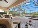 Screened lanai featuring a pool, spa, and comfortable seating overlooking the water at 13644 Brilliante Dr, Venice, FL 34293
