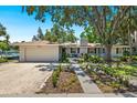 Charming single-story home with a two-car garage, a well-manicured lawn, and tasteful landscaping at 1542 Gulfview Dr, Sarasota, FL 34236