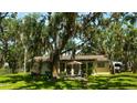 Home back exterior with patio seating, large yard, and a privacy fence at 1613 6Th W St, Palmetto, FL 34221
