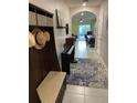 Inviting entryway with coat rack, bench, piano, and views of the dining room and living area at 16919 Trite Bend St, Wimauma, FL 33598