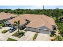 Aerial view of home showing driveway, tile roof, landscaping, and garage at 1951 San Silvestro Dr, Venice, FL 34285