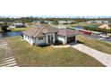 Waterfront property featuring a modern home, a brown roof, and paved driveway near intersecting roads at 197 Rotonda Cir, Rotonda West, FL 33947