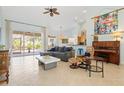 Spacious living room with vaulted ceilings, tile floors, comfortable seating, and natural light from sliding glass doors at 22324 Wexford Blvd, Venice, FL 34293