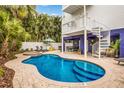 Backyard oasis featuring a sparkling pool, hot tub, bar, lounge chairs, and a spiral staircase at 318 64Th St, Holmes Beach, FL 34217