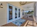Charming porch area with blue trim doors, starfish rug, and outdoor seating, perfect for enjoying the outdoors at 32 Palm Dr, Placida, FL 33946
