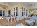 Cozy covered porch with outdoor dining table, seating, and charming nautical decor, great for entertaining guests at 32 Palm Dr, Placida, FL 33946