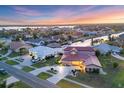 Stunning aerial view of a waterfront home with lush landscaping and a private dock on a canal community during sunset at 4405 Harbor Blvd, Port Charlotte, FL 33952