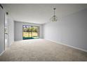 Bright, spacious living area with neutral carpet, and sliding glass doors overlooking golf course at 4580 Longwater # 61, Sarasota, FL 34235