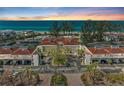 Beautiful aerial shot of a beachfront condo community with lush landscaping, tennis courts, and private parking at 5055 Gulf Of Mexico Dr # 232, Longboat Key, FL 34228