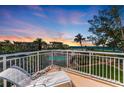 Charming balcony view overlooking tropical landscaping, a sparkling community pool, and the Gulf of Mexico at 5055 Gulf Of Mexico Dr # 232, Longboat Key, FL 34228