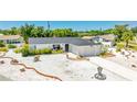 Beautiful one-story home with a white exterior, a well manicured yard and a concrete driveway at 6628 Keystone Dr, Sarasota, FL 34231