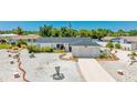 Beautiful one-story home with a white exterior, a well manicured yard and a concrete driveway at 6628 Keystone Dr, Sarasota, FL 34231
