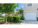 Exterior view showing two-car garage and home address surrounded by trees at 6770 Fairway Gardens Dr, Bradenton, FL 34203