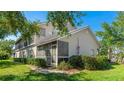 Rear exterior view featuring a screened-in porch and lush landscaping at 6770 Fairway Gardens Dr, Bradenton, FL 34203