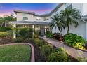 Charming home entrance with a brick walkway, lovely landscaping, and a screened porch at 7538 Camden Harbour Dr, Bradenton, FL 34212