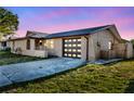 Charming single-story home with a modern garage door and well-maintained front lawn at 9430 Glen Moor Ln, Port Richey, FL 34668