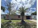 Charming single-story home featuring stucco siding, a garage, a well-maintained lawn, and mature trees at 9430 Glen Moor Ln, Port Richey, FL 34668
