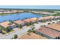 Aerial view of single Gathering homes in a lakeside community with beautiful landscaping and tile roofs at 7036 Highgate Ln, Lakewood Ranch, FL 34202