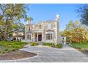 Elegant home featuring brick facade, a circular driveway, and a grand entrance with columns at 1577 Alexander Rd, Belleair, FL 33756