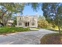 Stunning brick home boasting a circular driveway, manicured landscaping, and a grand entrance at 1577 Alexander Rd, Belleair, FL 33756