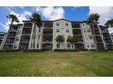 The rear of the condo building features screened patios and lush lawns enhanced by palm trees at 17118 Vardon Ter # 307, Bradenton, FL 34211