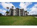 Rear exterior view of the condo, showing screened patios and a well-maintained lawn at 17118 Vardon Ter # 307, Bradenton, FL 34211