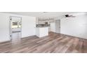 Open-concept living room with light wood flooring and a view into the modern kitchen, offering ample space at 2005 47Th Street W Ct, Bradenton, FL 34209