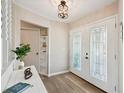 Inviting foyer featuring a decorative pendant light, wood-look flooring and updated glass paneled front doors at 217 Giotto Dr, Nokomis, FL 34275
