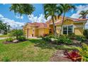 Inviting home with tropical landscaping, red tile roof, brick pavers, and a two-car garage at 410 Wellington, Venice, FL 34292