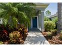Charming home featuring a brightly colored front door framed by lush, tropical landscaping at 4318 Deep Creek Ter, Parrish, FL 34219