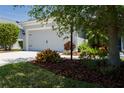 Two-car garage surrounded by lush, verdant landscaping and a freshly sealed driveway at 4318 Deep Creek Ter, Parrish, FL 34219