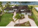 Aerial view of waterfront property with lush landscaping, pool, boat dock and brick circular driveway at 4355 Pompano Ln, Palmetto, FL 34221