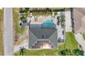 Aerial view of a home showcasing a pool, patio area, mature trees, and solar panels on the roof at 4440 Yacht Club Dr, Venice, FL 34293