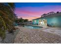 Stunning backyard oasis with a private pool, brick patio, spa, and lush tropical landscaping at 4440 Yacht Club Dr, Venice, FL 34293