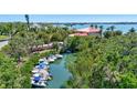 Canal with multiple boats docked, surrounded by lush greenery and a view of a large waterfront home at 519 Bayview Ave, Osprey, FL 34229