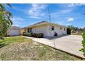 Side view features an outdoor shed, spacious driveway, and mature landscaping in a well-maintained yard at 519 Bayview Ave, Osprey, FL 34229