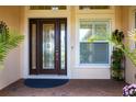 Stylish front door with decorative glass and side window, enhanced by well-manicured plants at 5502 Tidewater Preserve Blvd, Bradenton, FL 34208