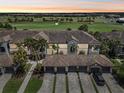 Aerial shot of a condominium complex showcasing tile roofs, multiple garages, and proximity to a golf course at sunset at 5528 Palmer Cir # 204, Lakewood Ranch, FL 34211