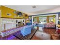 Bright living room featuring a stone fireplace, hardwood floors, and access to the pool area at 610 Poinsettia Rd, Nokomis, FL 34275