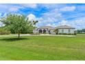 Lovely home with a circular driveway, three-car garage, well-manicured lawn, and lush landscaping at 6316 Foxbrook Trl, Parrish, FL 34219