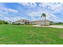 Expansive view of the home's exterior featuring a well-manicured lawn and lush landscaping at 6316 Foxbrook Trl, Parrish, FL 34219