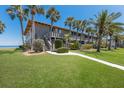Charming two-story condo with palm trees, green grass, and beautiful water view in a tropical setting at 6400 Flotilla Dr # 87, Holmes Beach, FL 34217