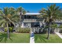 Attractive two-story condo featuring vibrant green grass, mature palm trees and well-kept landscaping at 6400 Flotilla Dr # 87, Holmes Beach, FL 34217