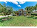 Well-manicured lawn and mature trees accent the exterior of this home with a paver driveway at 7814 48Th E Ave, Bradenton, FL 34203