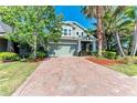 Charming two-story home with brick driveway, lush landscaping, and inviting curb appeal at 8243 Nandina Dr, Sarasota, FL 34240