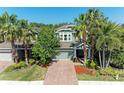 Charming two-story home with brick driveway, lush landscaping, and inviting curb appeal at 8243 Nandina Dr, Sarasota, FL 34240
