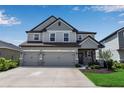 Beautiful two-story home with a three-car garage, gray paint, and welcoming front entrance at 8346 Abalone Loop, Parrish, FL 34219