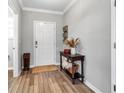 Warm foyer with wood-look flooring, decorative table, and natural light at 8346 Abalone Loop, Parrish, FL 34219